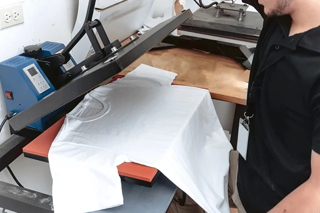 Man Operating Heat Press Machine for Sublimation Prints on T-Shirt