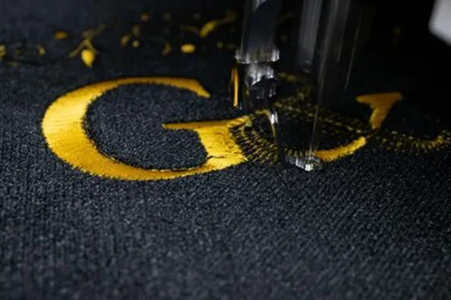 Close-Up of Stitched Embroidery on Black Fabric with Yellow Thread